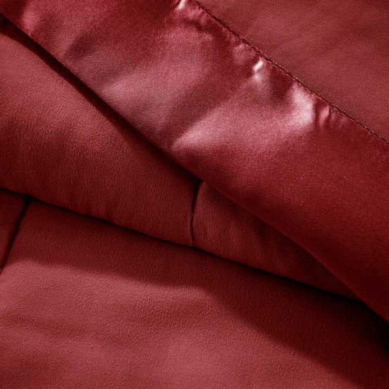 Close-up of Down Alternative Blanket Burgundy Twin - Budget Comfort showing soft texture and satin trim for a luxurious feel.