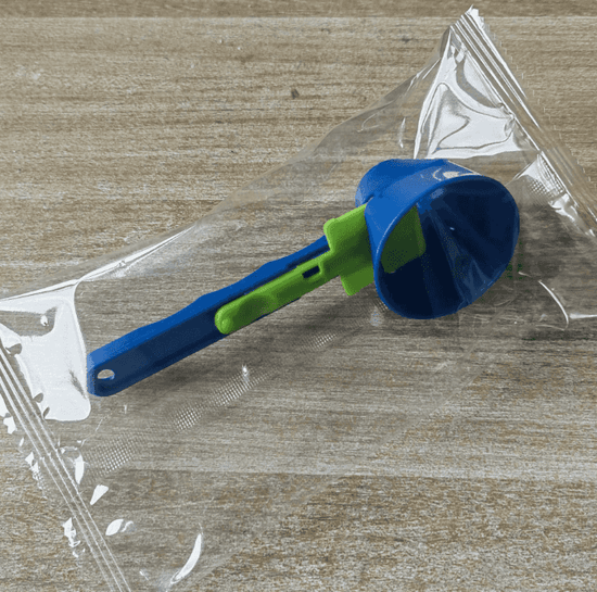 Blue and green measuring scoop on a wooden surface