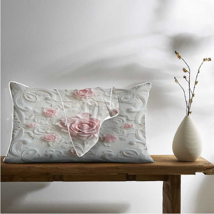 Decorative pillow with floral design on a wooden table next to a vase.