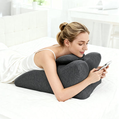 Woman using Ergonomic Memory Foam Bed Pillow - Spinal Support Pillow while lying on bed, offering lumbar support for comfort during phone use.