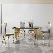 Modern black glass oval dining table with gold legs, styled with four chairs in a sleek, high-end dining room.