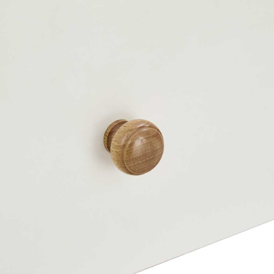 Close-up of the round wooden drawer knob on the white drawer of the shoe storage bench, emphasizing its minimalist design.