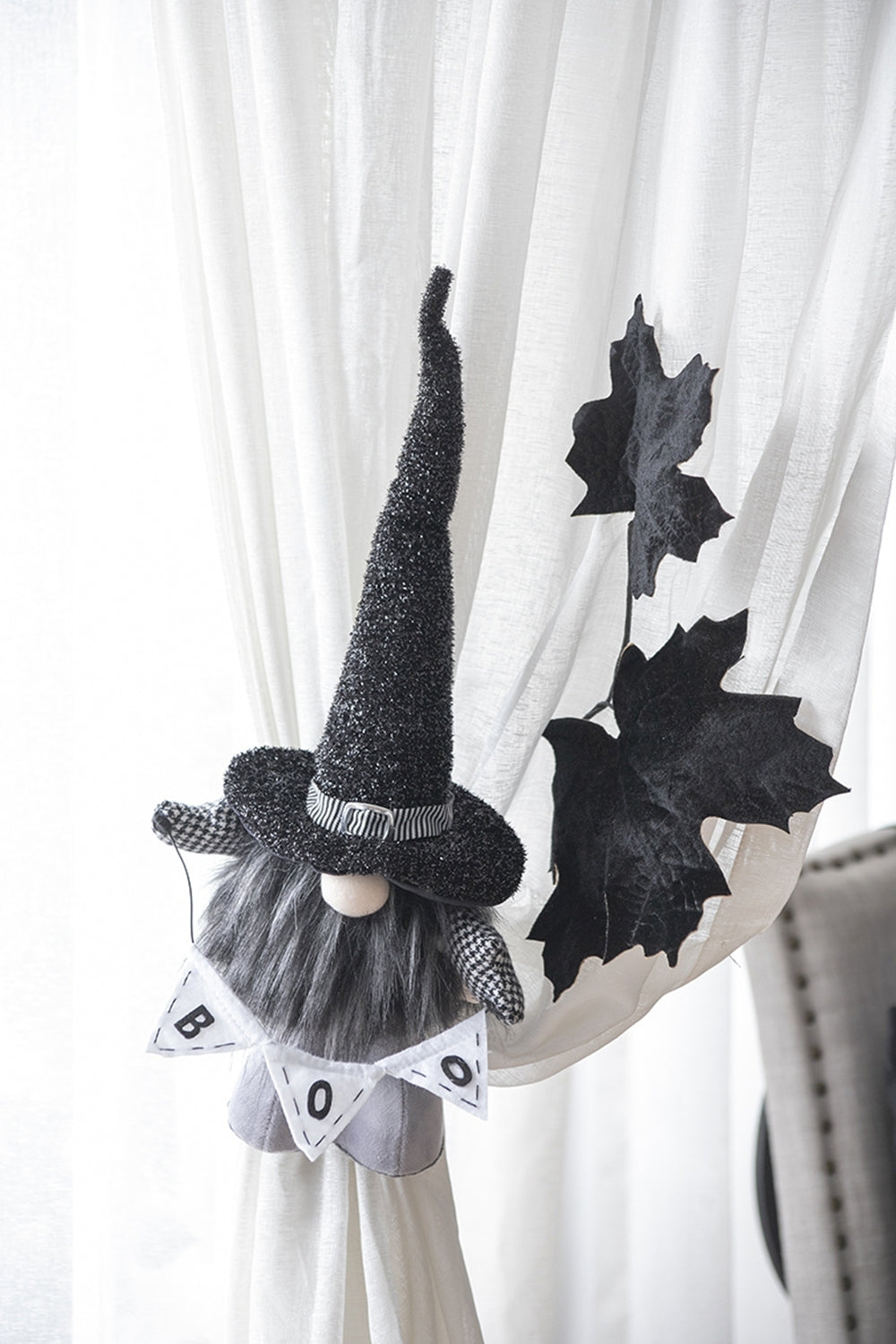 Halloween-themed gnome decoration with a banner on a curtain