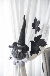 Halloween-themed gnome decoration with a banner on a curtain