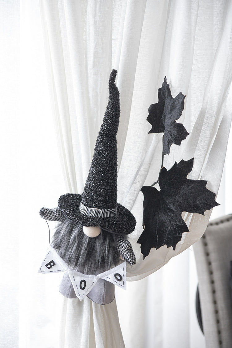 Halloween-themed gnome decoration with a banner on a curtain