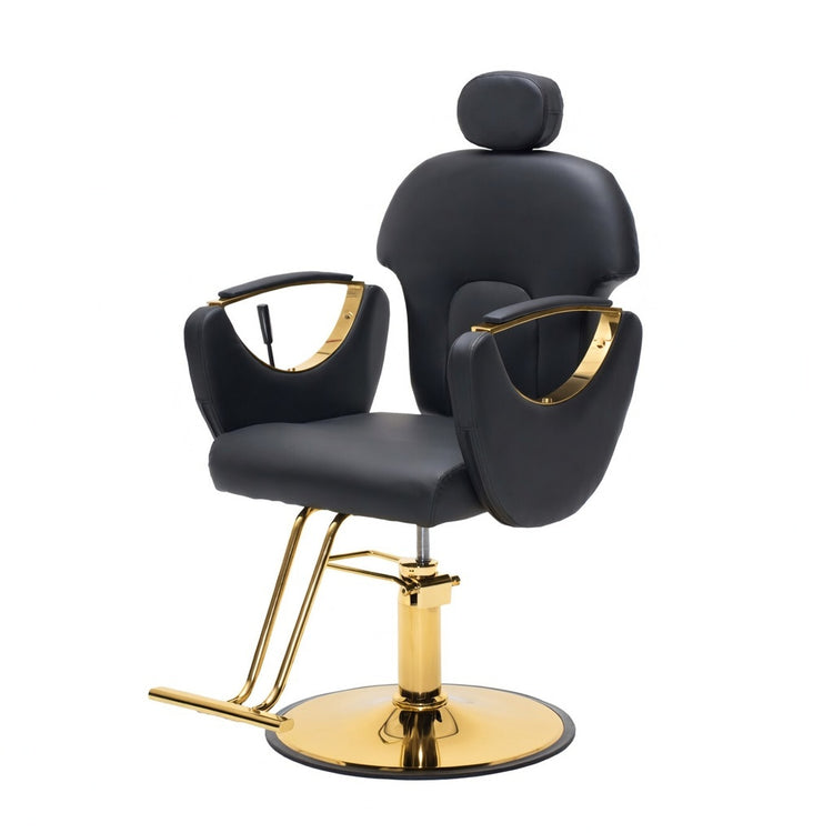 A modern barber-style salon chair with black padded upholstery and polished gold metal base, arm accents, and support legs, shown on a plain white background.