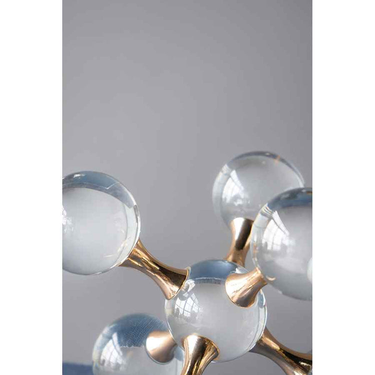 Modern chandelier with gold fixtures and clear glass shades on a gray background