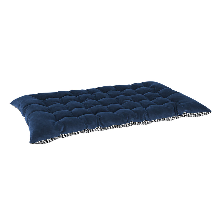 Navy blue quilted pet bed with checkered edge on a white background