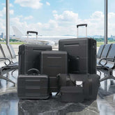 Set of black suitcases in an airport terminal with a plane visible through the window.