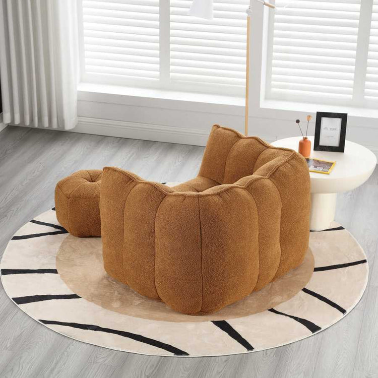 Brown textured armchair on a round rug in a room with light gray flooring and white walls.