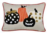 Decorative pillow with Halloween-themed pumpkins on a beige background
