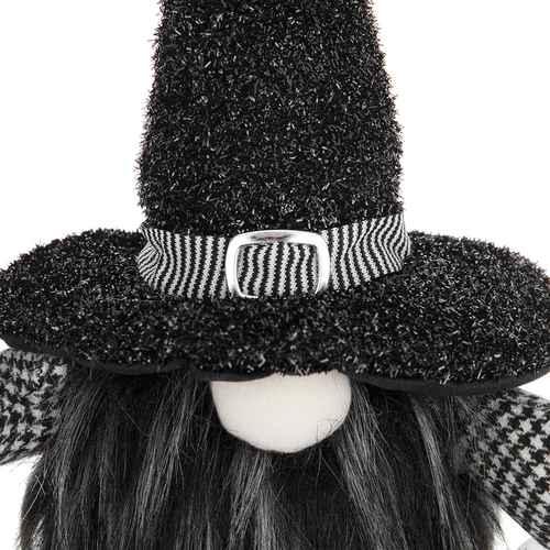 A close-up of a black witch-themed decorative figure or doll with a tall glittery black hat, a black-and-white striped band with a silver buckle, black hair, and a white face on a white background.