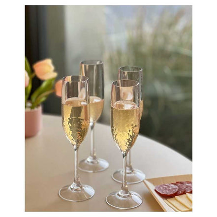 Set of 4 unbreakable plastic champagne flutes filled with bubbly, perfect for stylish outdoor or indoor celebrations.