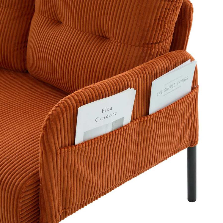 Brown textured sofa with a magazine holder containing books.