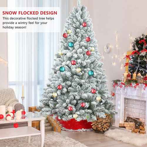 Flocked Christmas tree with pine cones beside wrapped gifts