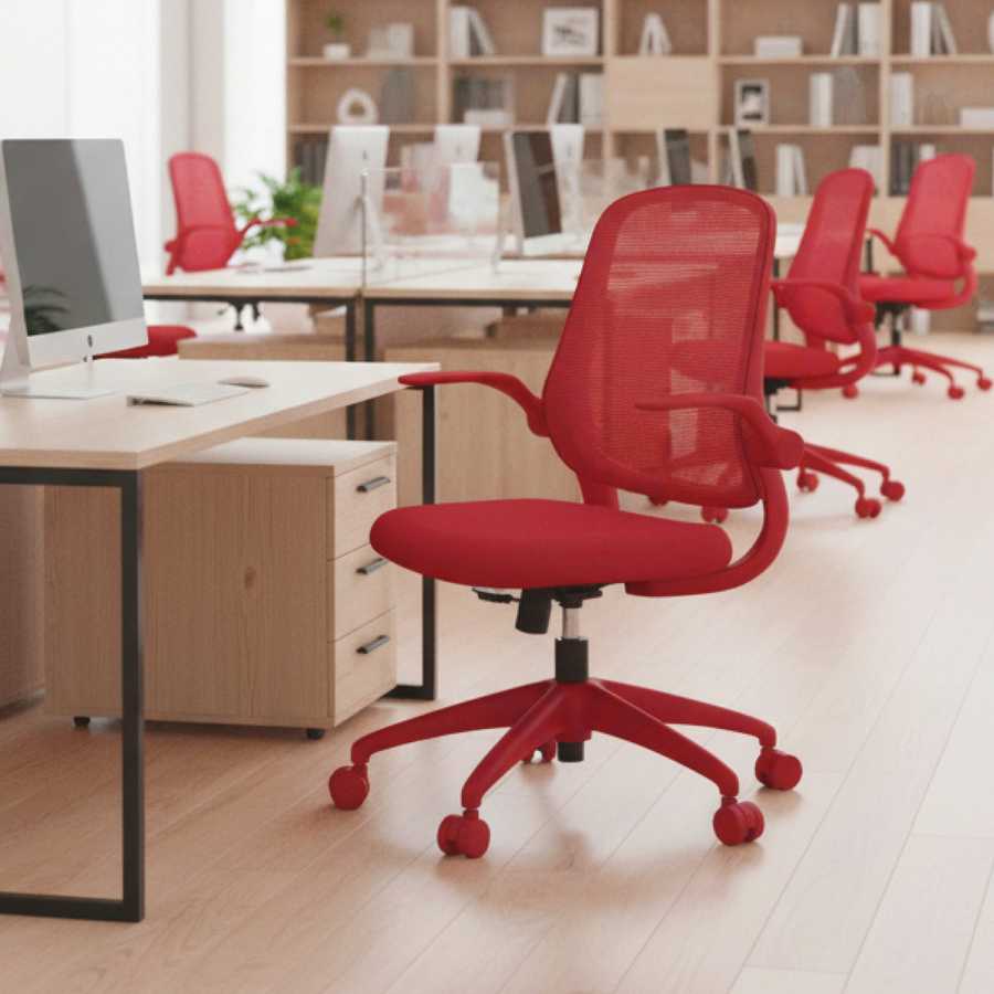 Red office chair in a modern office setting with desks and computers.
