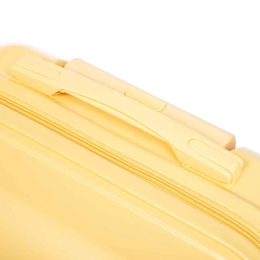 Close-up of yellow ABS luggage with zipper closure and smooth surface for secure packing and travel convenience