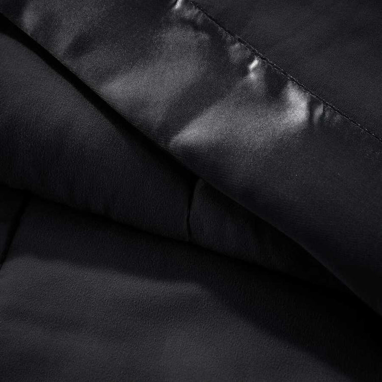Detailed view of black Lightweight Down Alternative Blanket fabric and satin trim, emphasizing smooth texture and high-quality finish.