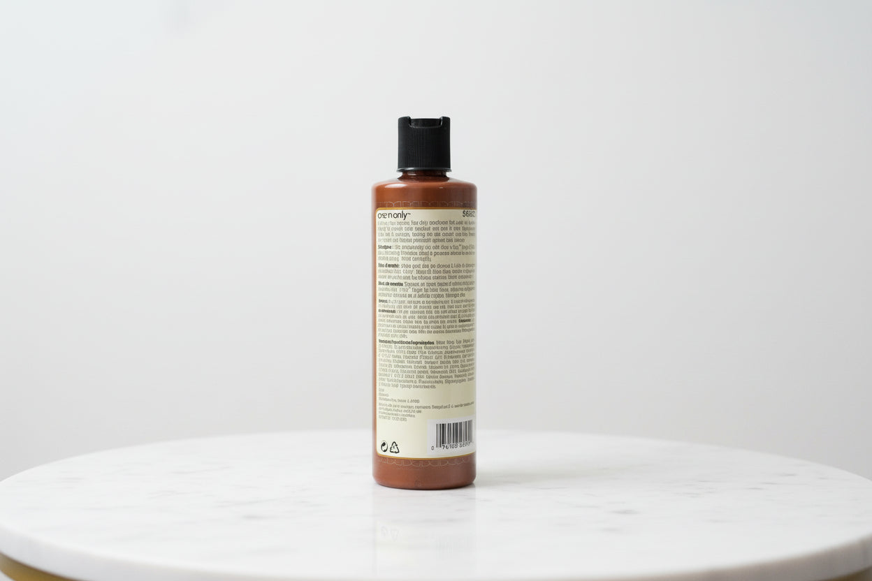 One N Only Argan Oil Color Oasis Smoothing Conditioner bottle placed on a marble surface, back label with product details visible.