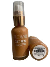 Two bottles of Flower Get Real Serum Foundation on a textured surface