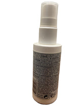 A white spray bottle of hair product, showing the back label with text, on a plain white background.