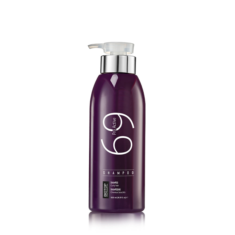 Purple shampoo bottle with pump on a white background