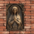 Metal Virgin Mary religious decor on brick wall