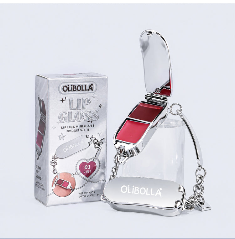 Olibolla Lip Gloss Mini Bracelet in shade 01 Pink, featuring a silver metal compact with an open lid, a clear pouch, and a silver chain, shown next to its silver retail box.