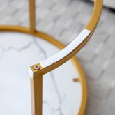 Detail of the gold metal frame and underside of the Nesting Round Coffee Table Set, showing sturdy construction and protective padding.