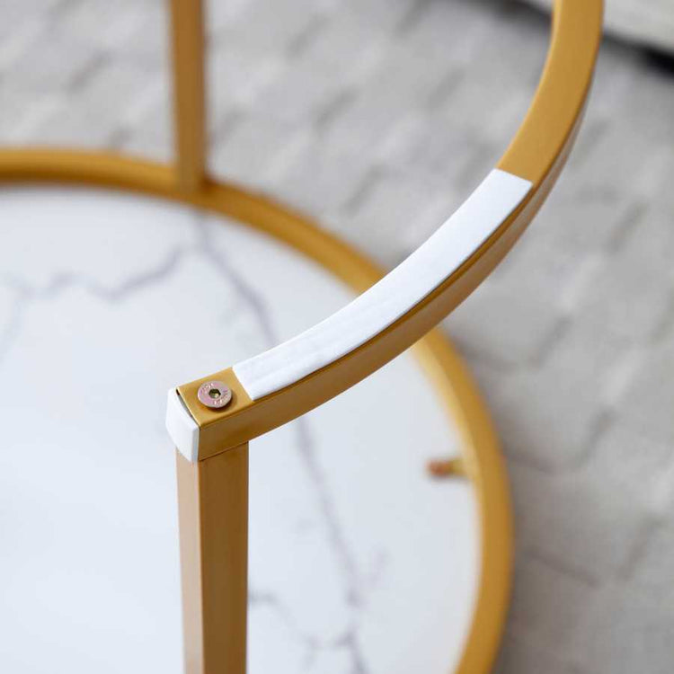 Detail of the gold metal frame and underside of the Nesting Round Coffee Table Set, showing sturdy construction and protective padding.