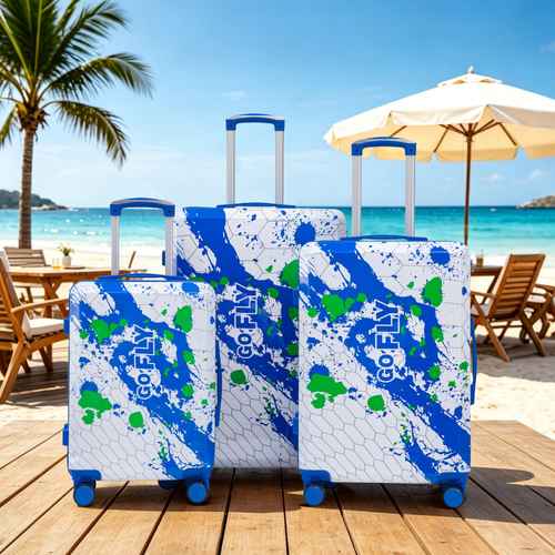 Three suitcases with blue and green patterns on a beach setting