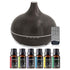 A dark brown wood-grain essential oil diffuser with a remote control and six small essential oil bottles labeled Sweet Orange, Tea Tree, Lavender, Eucalyptus, Lemongrass, and Peppermint, arranged on a white background.