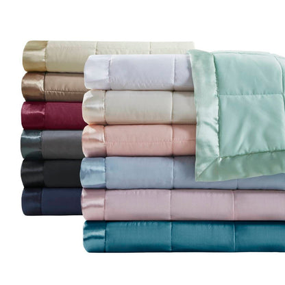 Close-up of folded Lightweight Down Alternative Blankets in multiple colors, highlighting soft texture and satin trim for luxury bedding.