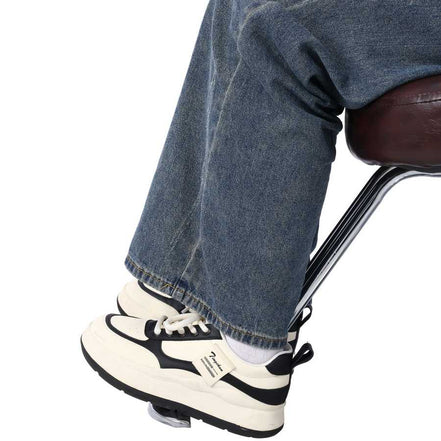 Close-up of client’s feet resting on Heavy Duty Barber Chair footrest, highlighting comfort during hairdressing sessions.