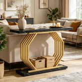 A modern hexagonal console table with a black marble top and base, and a gold-toned geometric metal frame, styled in a bright living room.