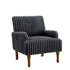 Gray ribbed armchair with wooden legs in a room with large windows and a plant.