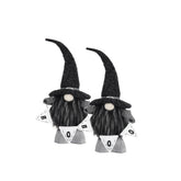 Two black and white Halloween gnome decorations with tall glittery black hats, long black beards, and white pennant banners that spell BOO, shown on a plain white background.