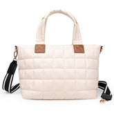 Beige quilted handbag with brown leather accents on a white background