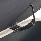 Close-up of a metal hinge on a dark fabric surface