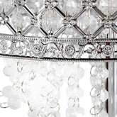 Close-up of a silver-toned chandelier or hanging light fixture with clear faceted crystal beads, a decorative metal band, and hanging clear crystal drops against a white background.