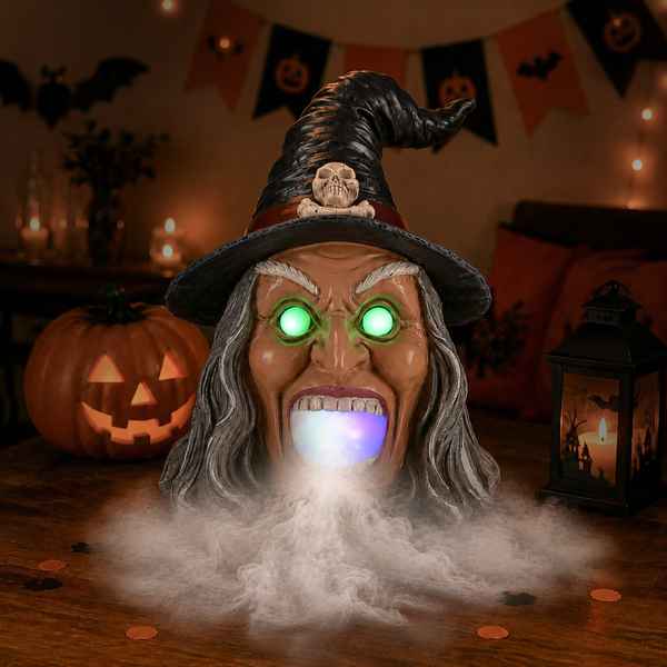 Close-up of Halloween witch head with glowing eyes, wide open mouth, purple hat with skull, Halloween decorations, dim lighting