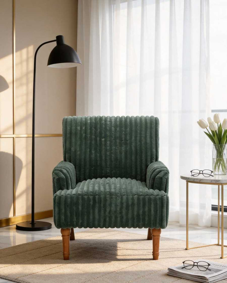 Green armchair in a living room with a lamp and table in the background