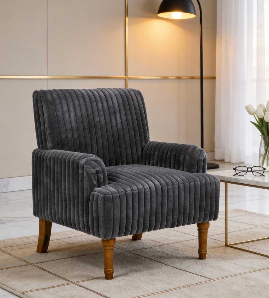 Gray upholstered armchair in a room with a lamp and table.