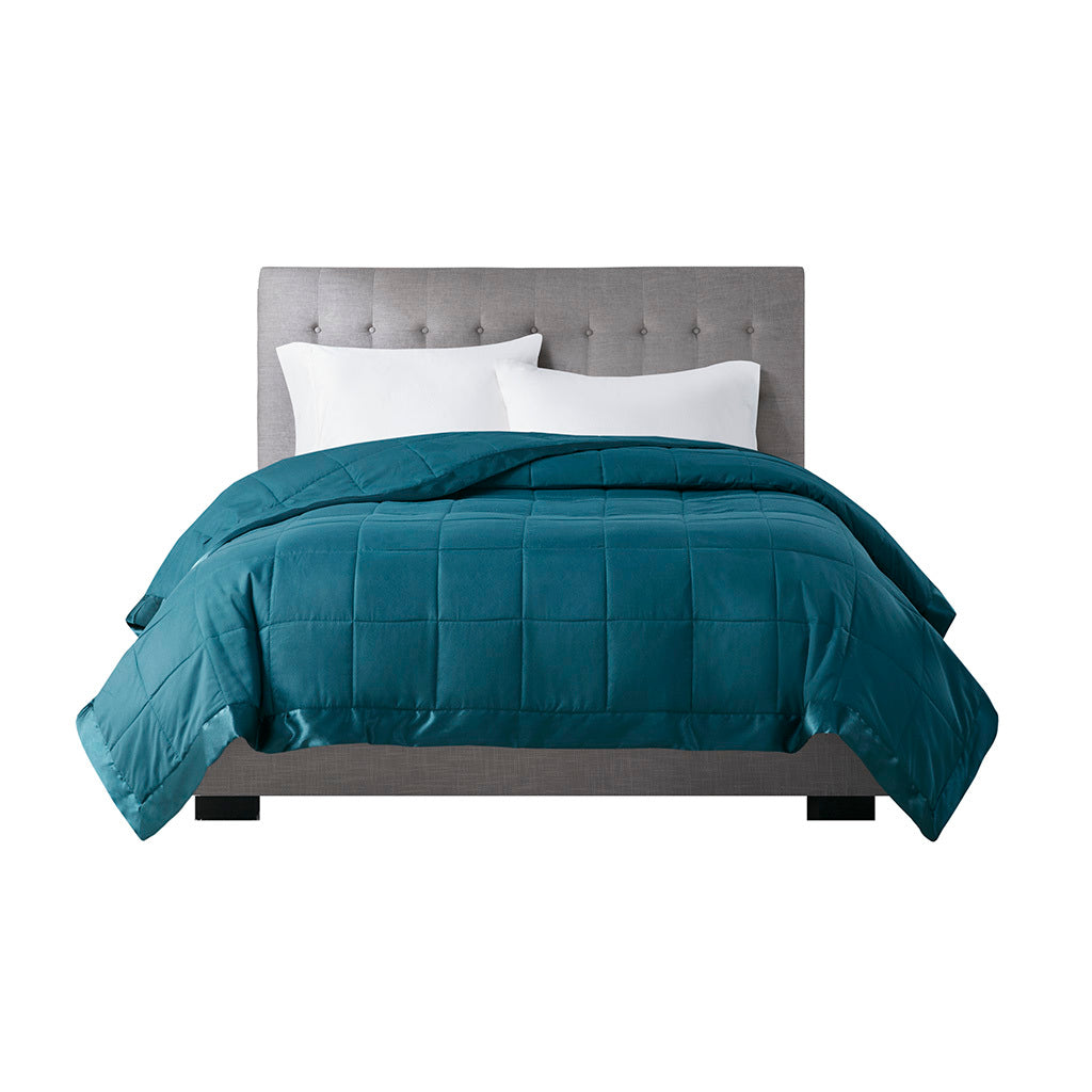 Front view of Teal Twin Down Alternative Blanket on bed, highlighting box quilting and satin trim for elegant bedroom style.