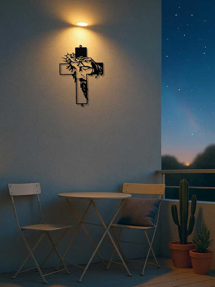 Metal Cross Wall Art Decor with Jesus face silhouette displayed on a balcony wall. Weather-resistant metal perfect for outdoor use.