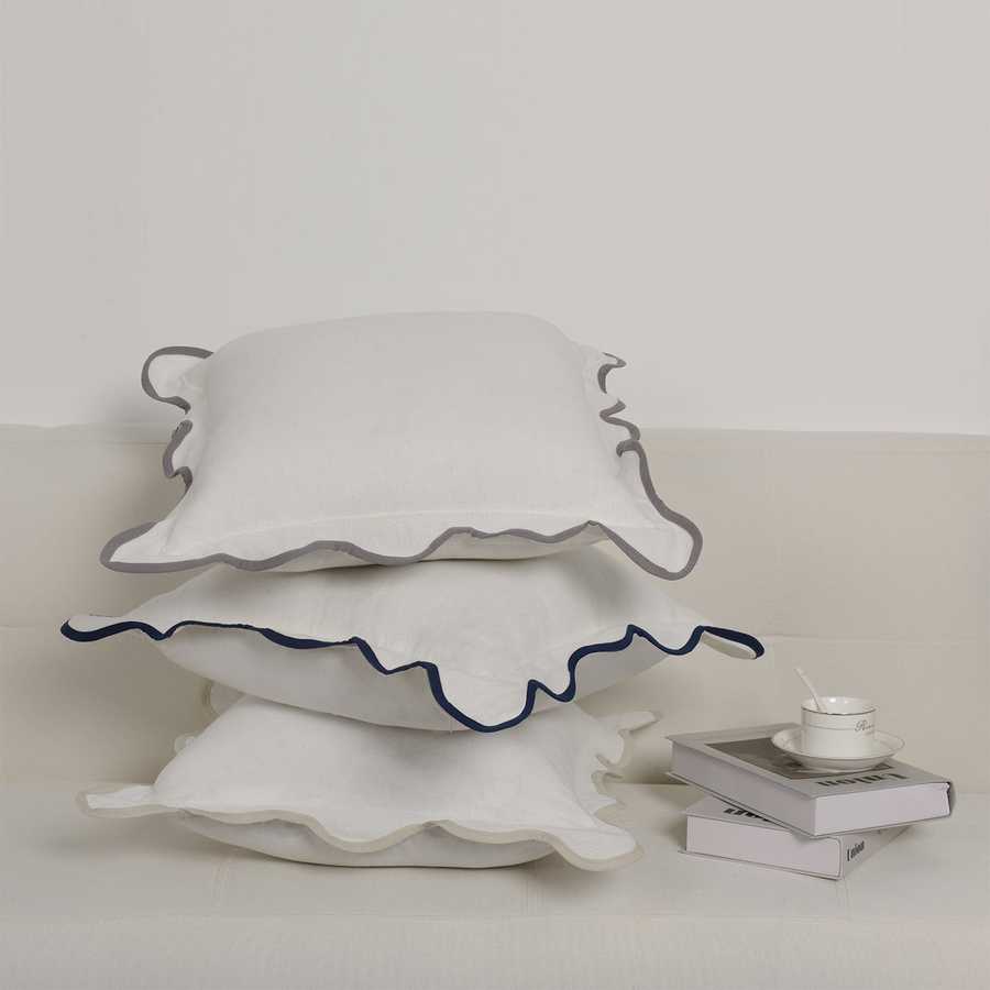 White ceramic cake stand with scalloped edge on a light background