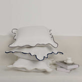 White ceramic cake stand with scalloped edge on a light background