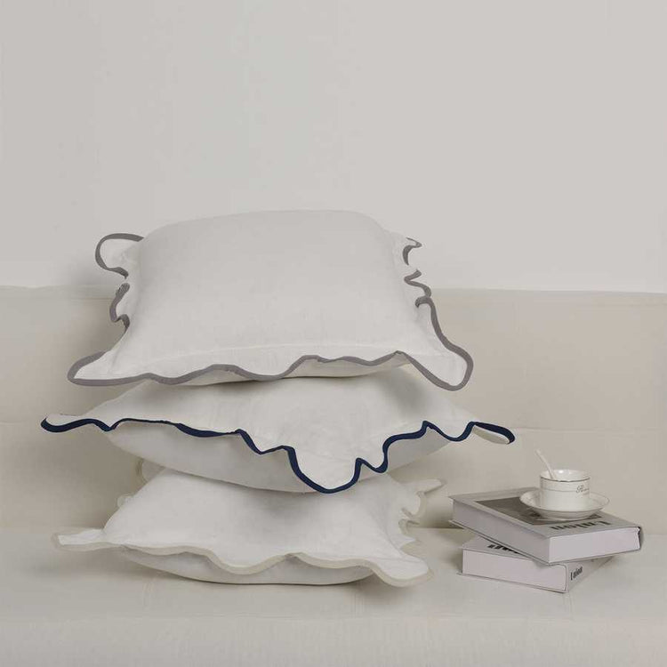 White ceramic cake stand with scalloped edge on a light background