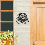 Black fish wall decor with trees and 'Welcome' banner on brick wall