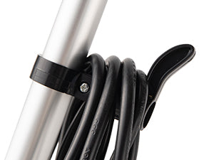 A close-up of a black cable loop or clip holding a coiled black cable around a silver metal pole, shown against a plain white background.